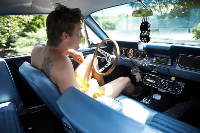 Mann entspannt beim Autofahren in einem Oldtimer
