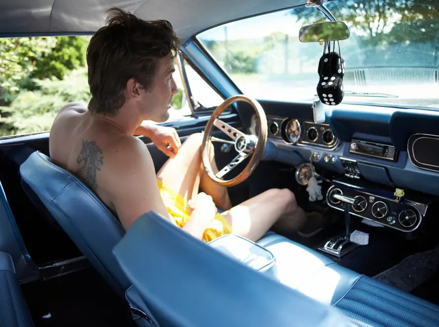 Mann entspannt beim Autofahren in einem Oldtimer